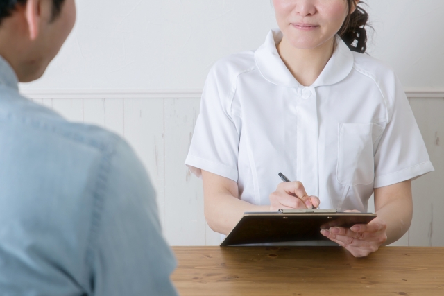 ヒアリングする白衣の女性
