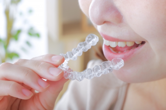 歯科用マウスピースを装着する若い女性