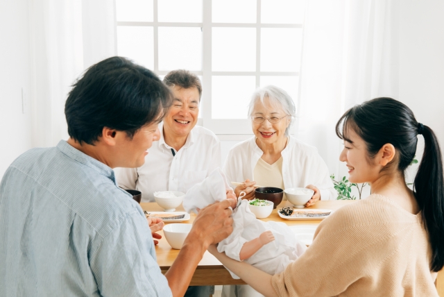 里帰り出産・食事をする老夫婦と若い夫婦