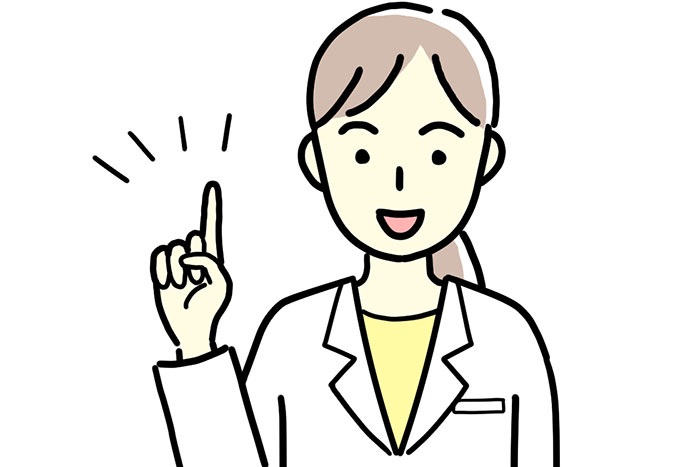 笑顔で人差し指を立てる白衣を着た歯医者の女性先生